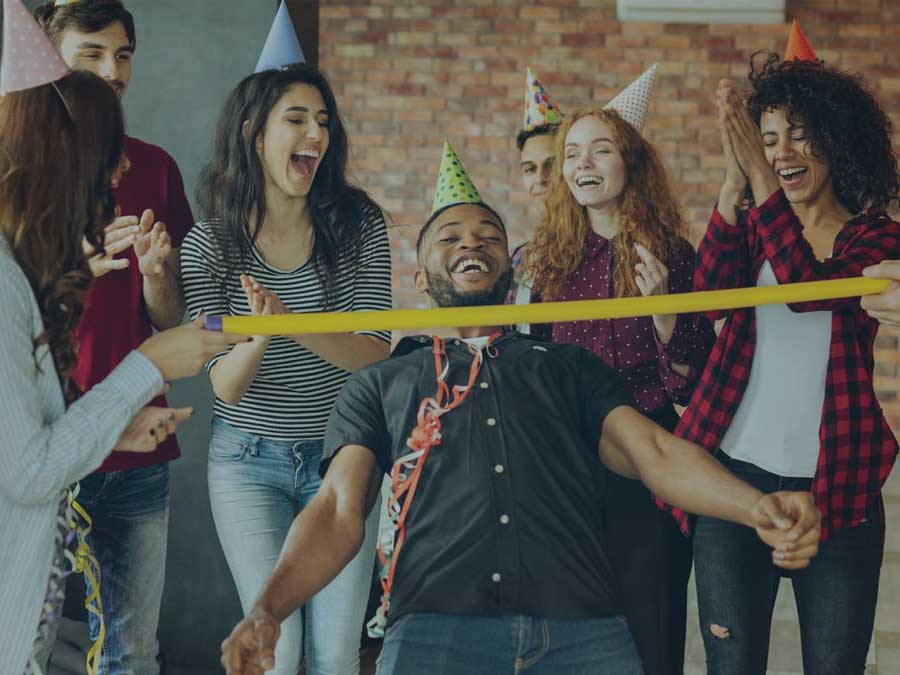 Photo of colleagues doing birthday limbo at office celebration