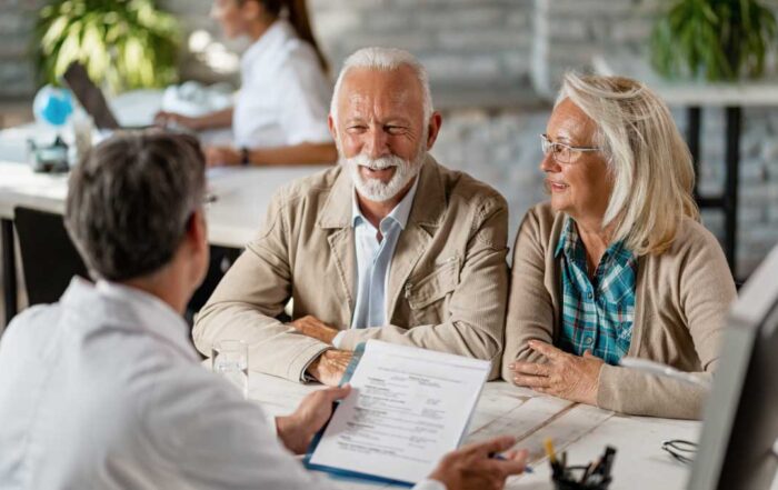 Photo of couple with healthcare consultant reviewing Medicare Advantage AEP must dos checklist