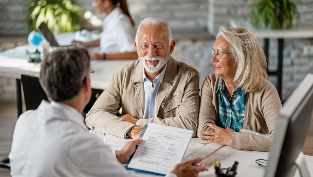 Photo of couple with healthcare consultant reviewing Medicare Advantage AEP must-dos checklist