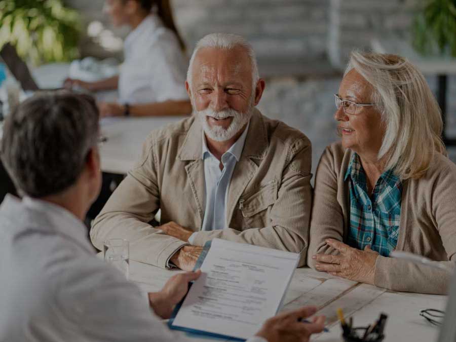 Photo of couple with healthcare consultant reviewing Medicare Advantage AEP must-dos checklist