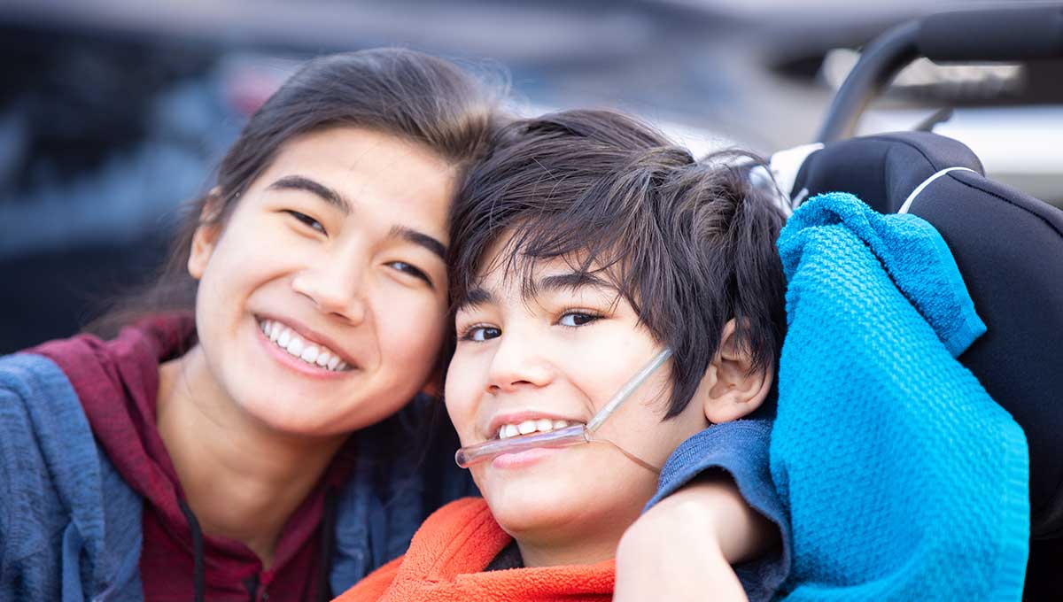 Photo of caregiver sister in service of others smiling with brother