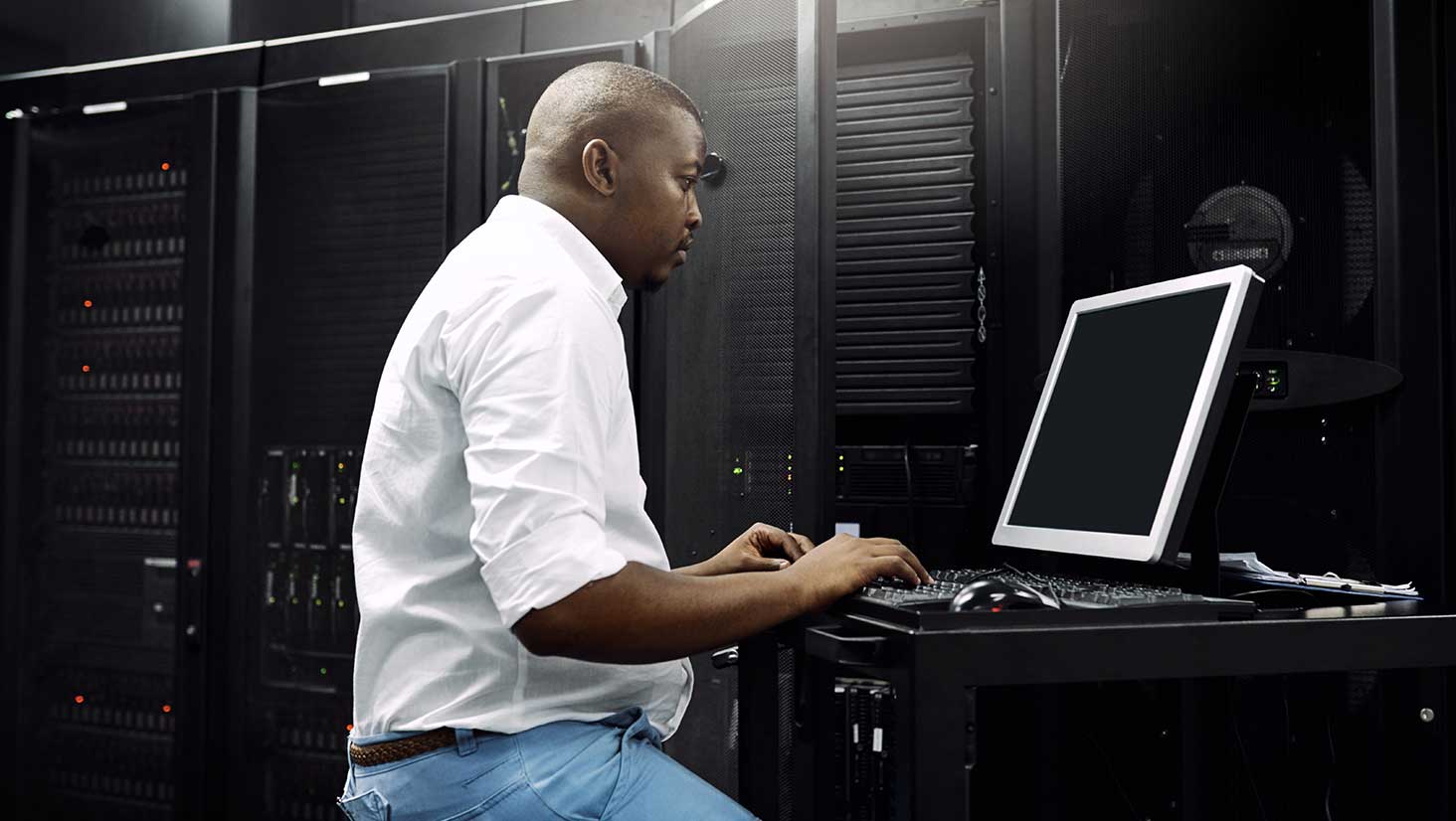 Photo of engineer with server working on IT challenges