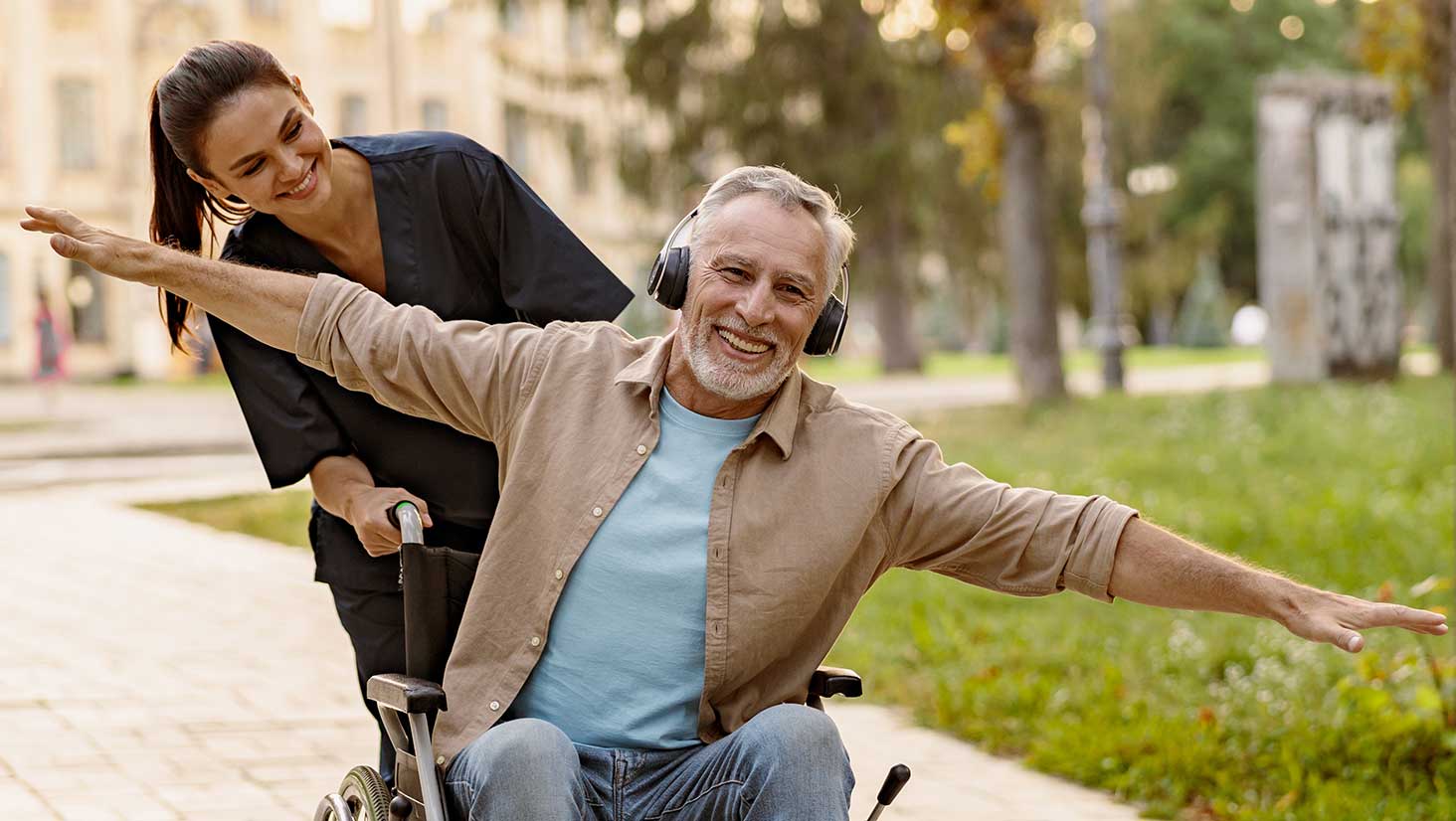 Photo of nurse pushing man in wheelchair