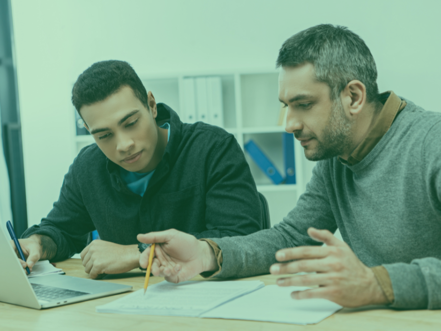 concentrated male coworkers working with papers and laptop in office