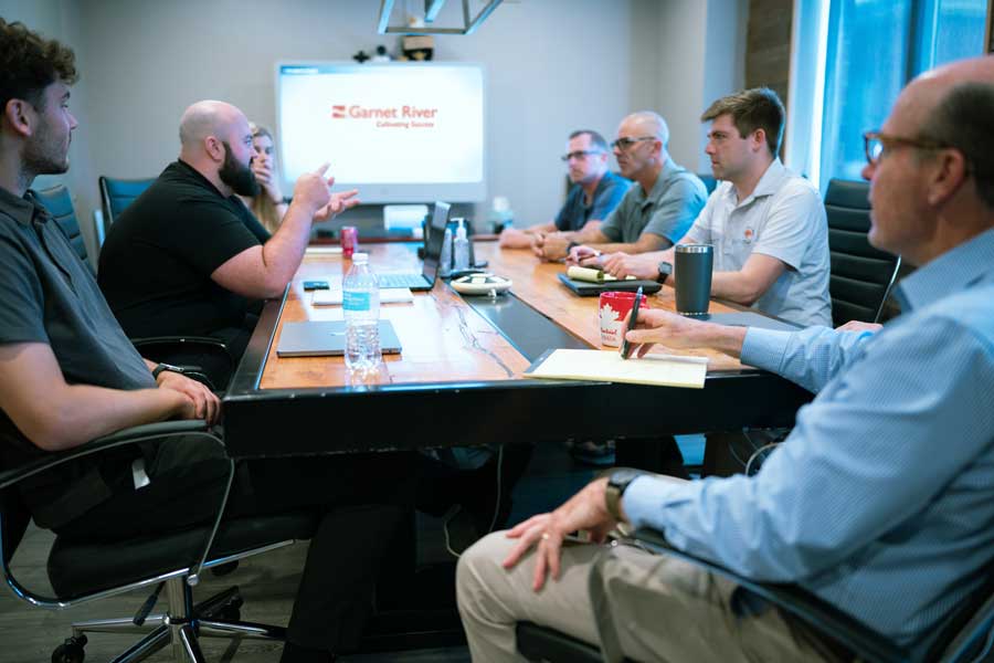 Garnet River team members around conference table discuss product updates