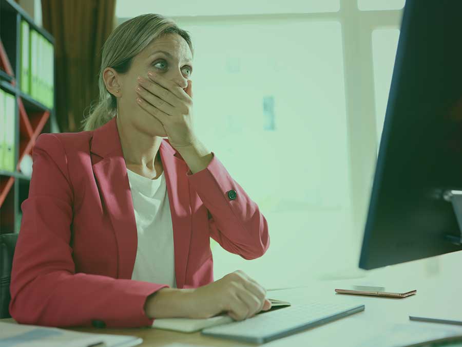 Woman in front of computer, reacting to email from HR